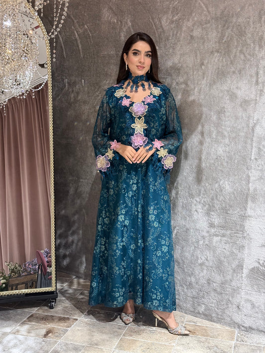 Woman in a Majestic Teal Floral Lace Luxury Kaftan dress standing in front of a mirror.