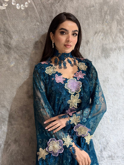 Woman in a Majestic Teal Floral Lace Luxury Kaftan  floral embroidered dress lying on a textured surface