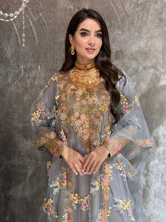 Woman in a Grey Luxury Embroidered Kaftan embroidered traditional outfit standing on a textured surface
