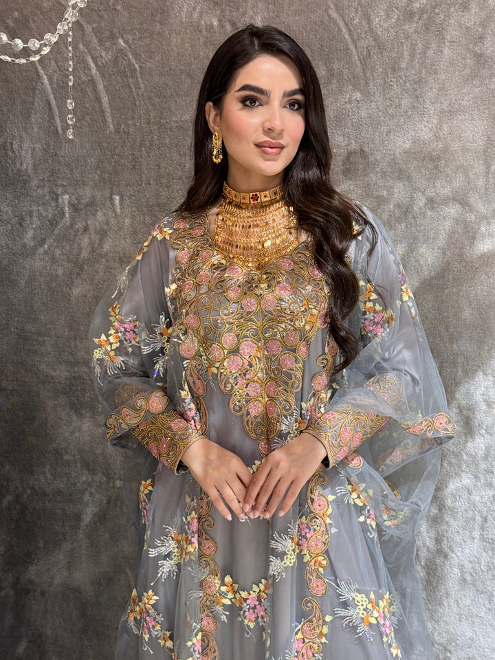 Woman in a Grey Luxury Embroidered Kaftan embroidered traditional outfit standing on a textured surface