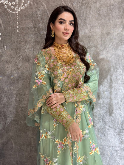 Woman in a Mint Green Luxury Kaftan dress standing against a textured wall.