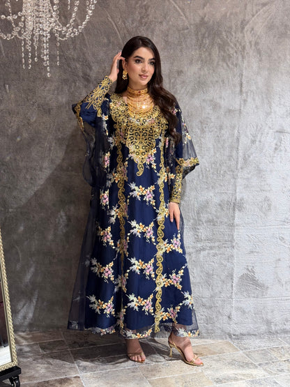 Woman in a O 285 Navy Luxury Embroidered Kaftan standing on a reflective floor.