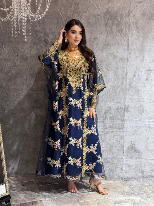 Woman in a O 285 Navy Luxury Embroidered Kaftan standing on a reflective floor.