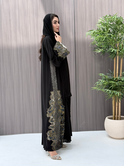 a woman wearing an elegant open-front black abaya featuring intricate multi-colored beadwork, sequins, and metallic embroidery in an indoor setting.