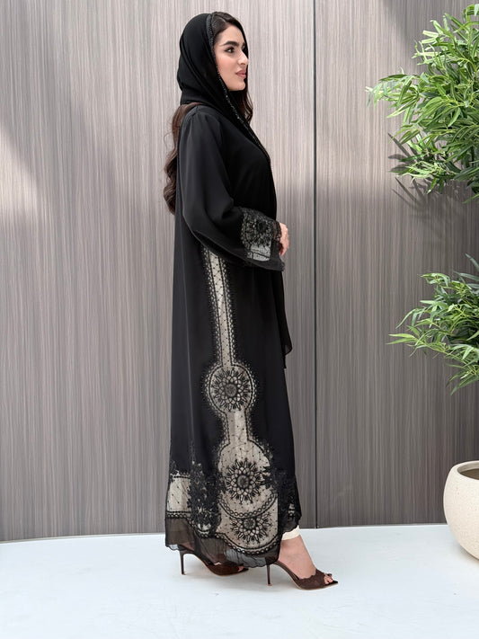 Woman wearing a luxury open-front black abaya crafted from premium Nida fabric with matching sheila standing indoor