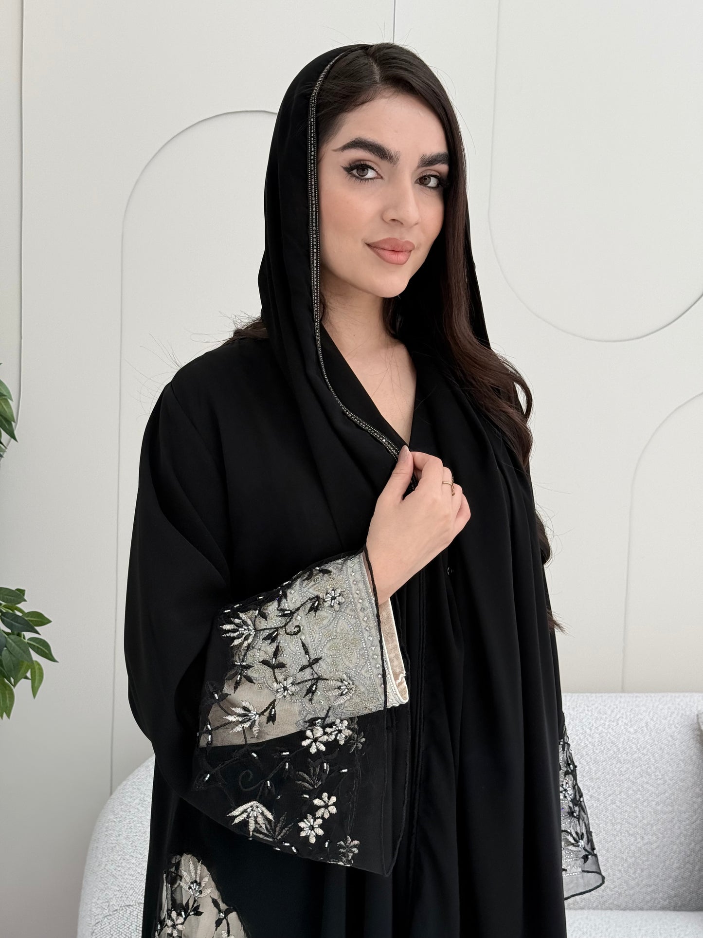 Woman wearing an elegant luxury open-front black abaya crafted from premium Nida fabric with a matching sheila.
 on a white background