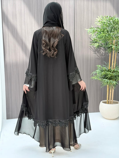 a woman wearing Black abaya with floral embroidery on a wooden floor