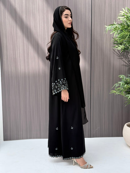 A woman wearing a black embroidered floral open abaya, which is perfect for ceremonies, Eid, and parties.