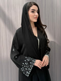 A woman wearing a black embroidered floral open abaya, which is perfect for ceremonies, Eid, and parties.