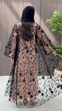Woman wearing a Black Sheer Floral Appliqué Open Front Abaya with a mathcing sheila against a wooden panel background