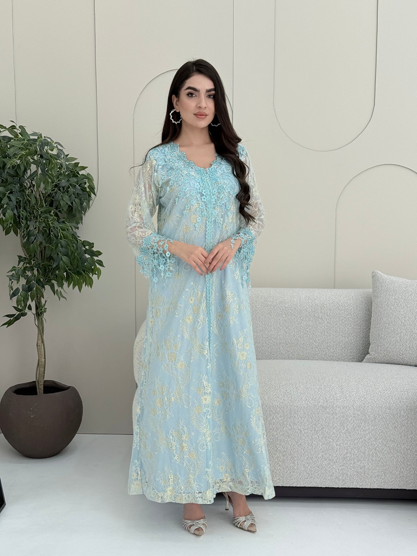 A woman wearing a baby blue floral lace kaftan, perfect for Eid, luxury occasions and parties.
