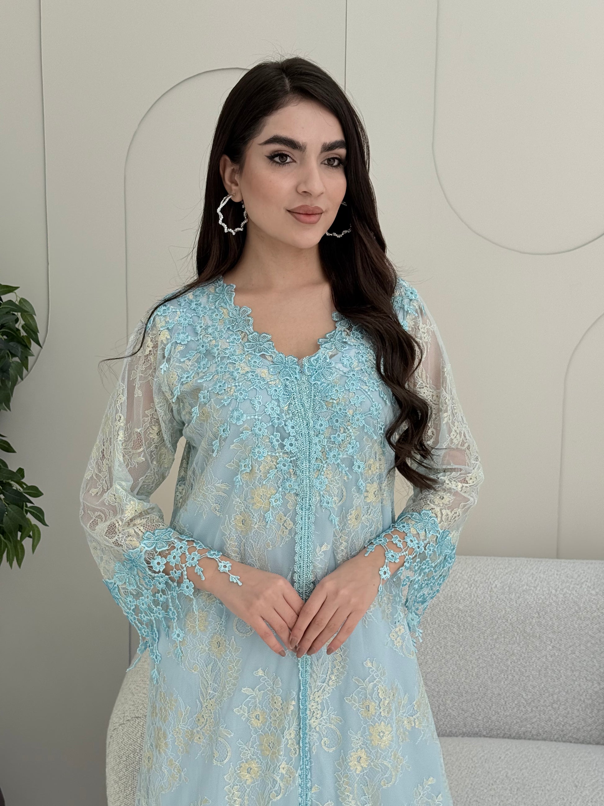 A woman wearing a baby blue floral lace kaftan, perfect for Eid, luxury occasions and parties.