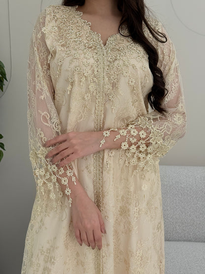 A woman wearing a cream floral lace kaftan, perfect for Eid, luxury occasions and parties.