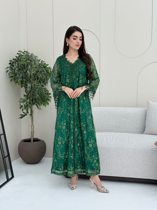 A woman wearing an emerald green floral lace kaftan, perfect for Eid, luxury occasions and parties.
