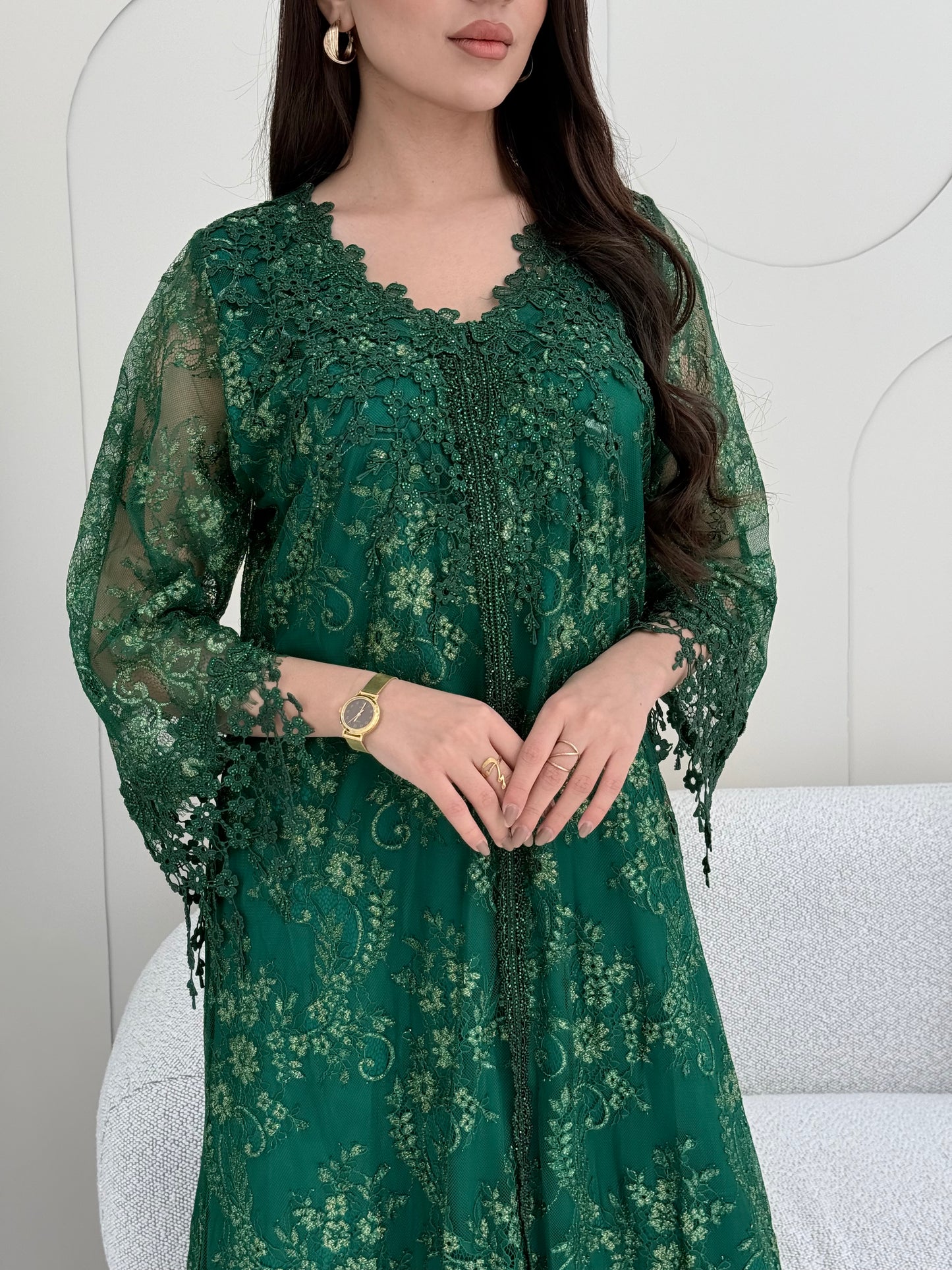 A woman wearing an emerald green floral lace kaftan, perfect for Eid, luxury occasions and parties.