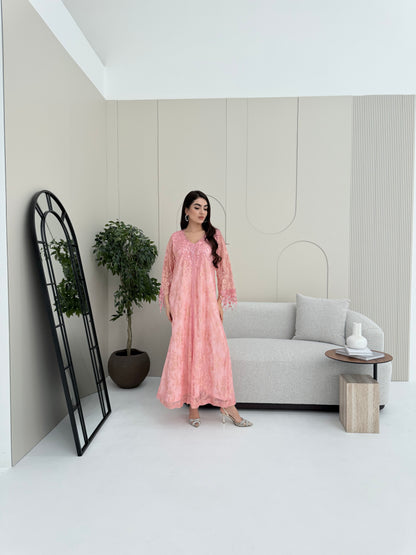 A woman wearing a pink floral lace kaftan, perfect for Eid, luxury occasions and parties.