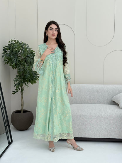 A woman wearing a mint green floral lace kaftan, perfect for Eid, luxury occasions and parties.
