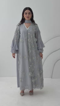 A luxurious light grey abaya with chiffon and texture of Black floral lace. This abaya is perfect for evening outings and occasions.